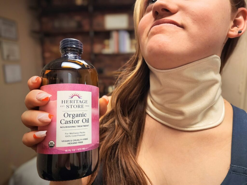 A woman applying castor oil pack to her neck for cyst and bump in thorat and neck